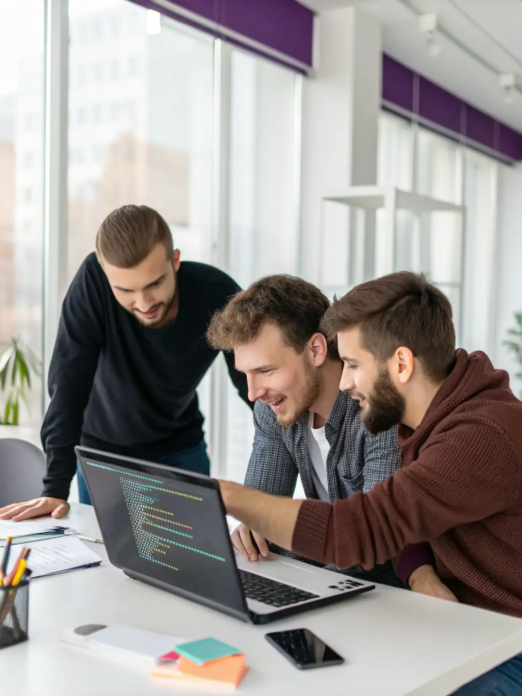 A professional photograph of software developers collaborating on a project, showcasing teamwork and expertise in custom software development for Medi Solutions LLC.